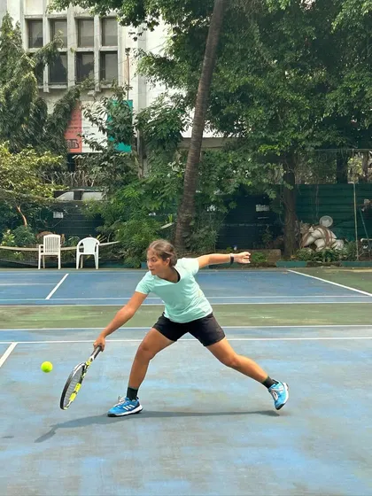 A player lunges for a low volley, showcasing her determination and athleticism in the finals.