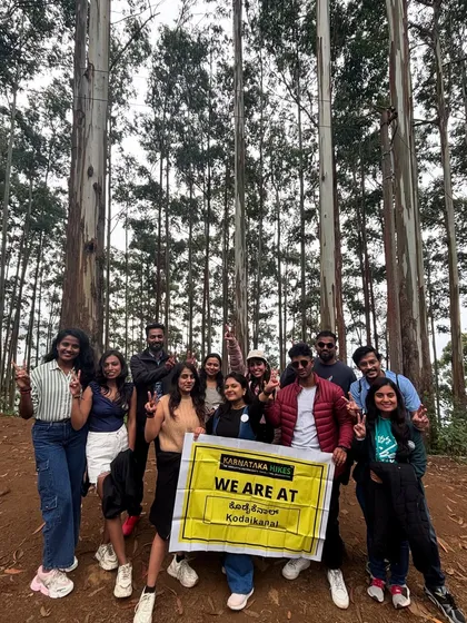 Our group with the banner in the tall, atmospheric pine forests of Kodaikanal.