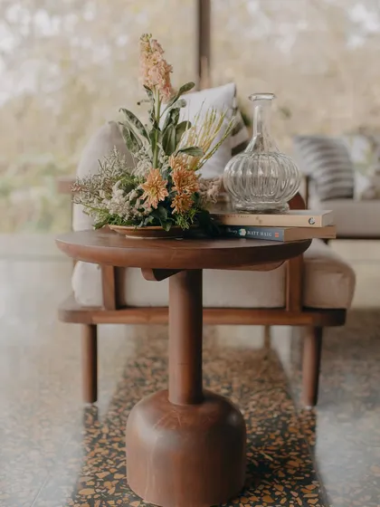 A close-up of the carefully chosen decor, including a wooden side table and a beautiful floral arrangement, reflecting our commitment to natural elegance.