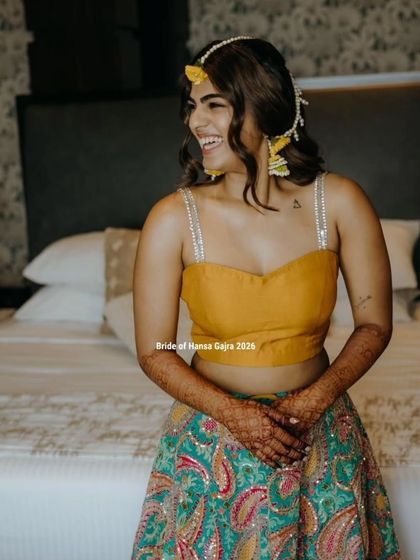 A happy bride during her haldi ceremony. Her simple mehendi complements her vibrant yellow and turquoise outfit and her joyful, infectious smile.
