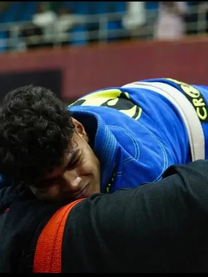 The face of exhaustion and determination. This is the reality of a tough Jiu-Jitsu match, pushing through pain to secure a dominant position.