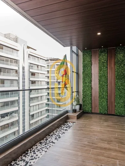 This balcony is transformed into a green oasis with a vertical garden wall. The combination of wood, stone pebbles, and artificial turf creates a low-maintenance yet refreshing outdoor space.