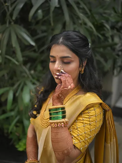A close-up of the bride's hand with the nath, showcasing the soft and subtle makeup.