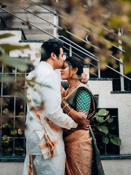 A tender moment as the groom kisses his bride's forehead. This close-up shot captures the intimacy and affection between the couple on their wedding day.
