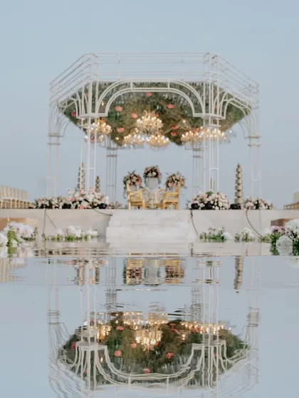 The sanctity of a vow, reflected. I designed this seaside mandap with a mirrored aisle, creating a breathtaking illusion where the structure, the sky, and the ceremony itself were perfectly duplicated, doubling the grandeur of the moment.