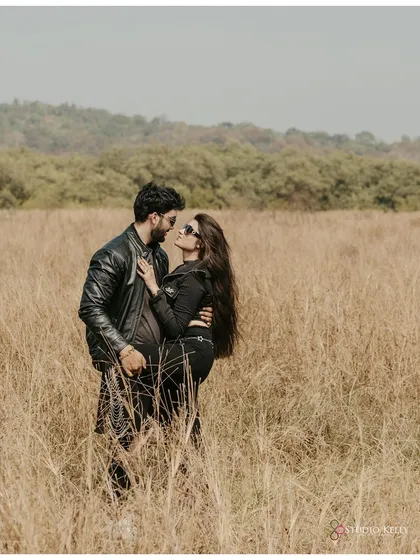 An intense and romantic portrait of the couple in a field in Goa. Their all-black, edgy outfits contrast with the natural surroundings, creating a striking visual.