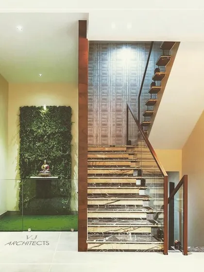 This staircase area features a vertical garden wall, bringing a touch of nature indoors. The glass partition keeps the space feeling open while creating a serene focal point.