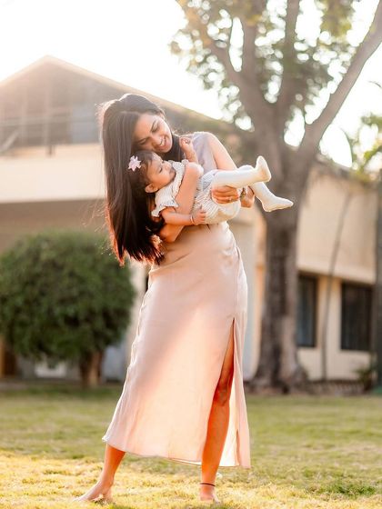 A mother gently holding her baby in the soft afternoon light. This portrait captures the tenderness and serenity of early motherhood in a natural, outdoor setting.