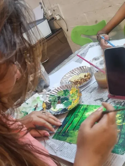 An online class in session, this student follows along on her phone to create a lush green forest scene, showing that you can learn from anywhere.