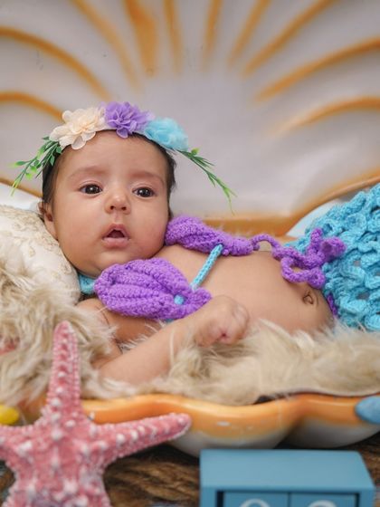 A final shot of the baby mermaid, looking calm and content in her cozy shell.