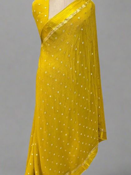 A sunny yellow Chinnon saree with a satin border and delicate butis.