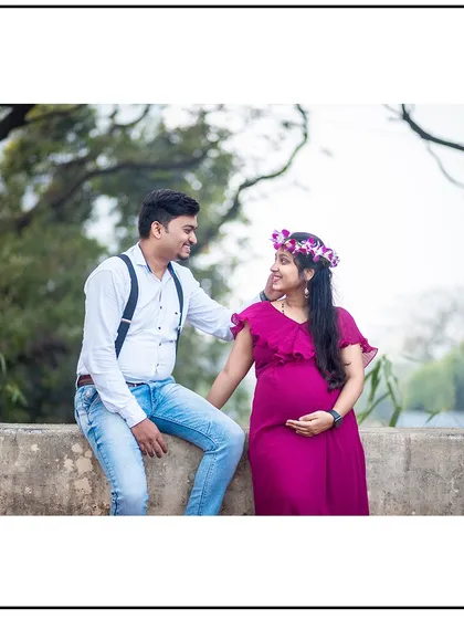 A relaxed and happy moment, with the couple sitting on a ledge and sharing a smile.