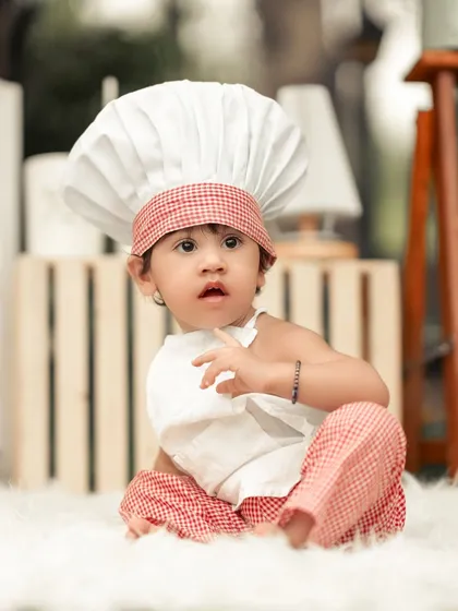 A thoughtful moment for our little chef. The soft, fluffy rug and rustic props create a cozy and charming atmosphere for this kitchen-themed shoot.
