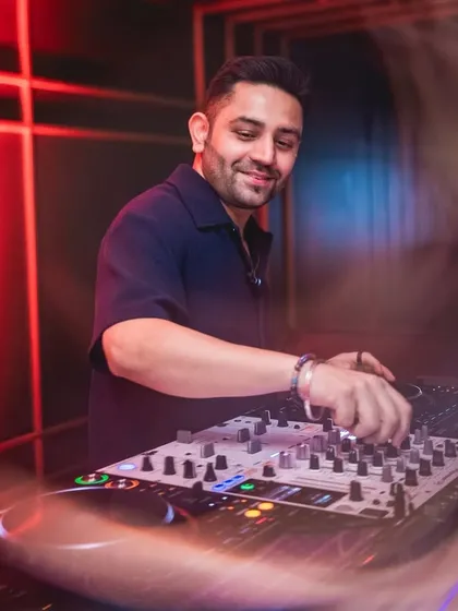 Focused on the mixer, crafting the perfect blend of tracks.