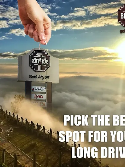 A creative graphic depicting a hand picking Big Bay from the clouds, positioning us as the best spot for your long drives, high above the rest.