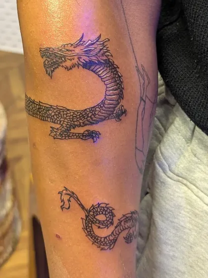 A serpentine dragon designed to wrap around the forearm. This piece uses clean linework to create a sense of movement, following the natural curve of the arm.