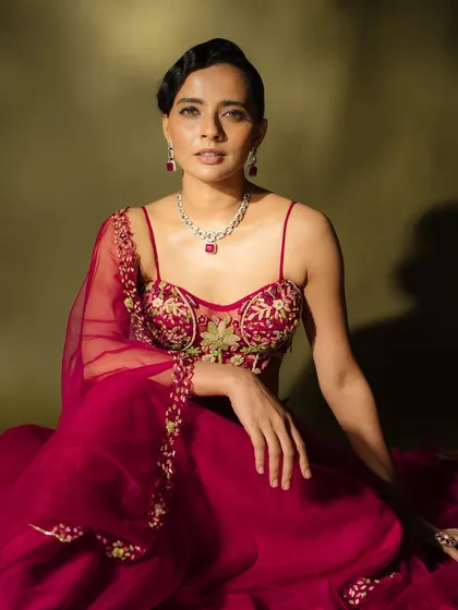 "Elegance in motion." A seated portrait that feels both powerful and serene. The makeup is sophisticated, with a focus on a flawless base and subtle color.