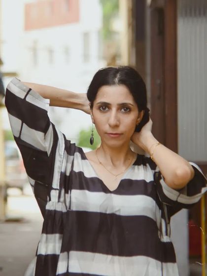 A close-up street style portrait for House of Wandering Silk, capturing a feeling of urban calm and effortless style.