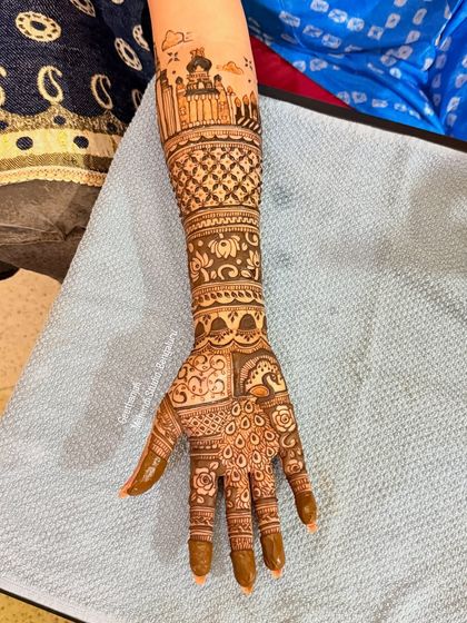 A full arm view of the custom skyline mehendi, blending architectural drawings with traditional henna patterns.