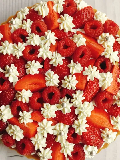 A celebration of freshness, this is my signature raspberry and strawberry cheesecake tart. I top a creamy, rich cheesecake base with a generous layer of fresh berries and delicate whipped cream dollops for a perfect balance of sweet and tart.