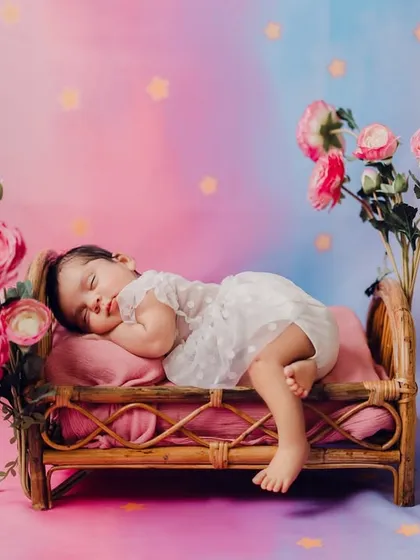 A tiny princess dreaming in a floral wonderland. Using a miniature rattan bed, soft pastels, and delicate flowers, I create serene and artistic portraits of newborns. Every detail is thoughtfully arranged for a beautiful result.