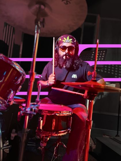 Our drummer, complete with headphones and a cool bandana, keeping the rhythm tight. Every performance is a step forward in their musical journey.