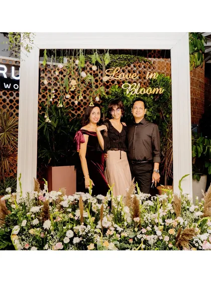 A custom "Love in Bloom" photo booth we designed for an anniversary. The elegant frame and floral surround create a perfect spot for guests to capture memories.