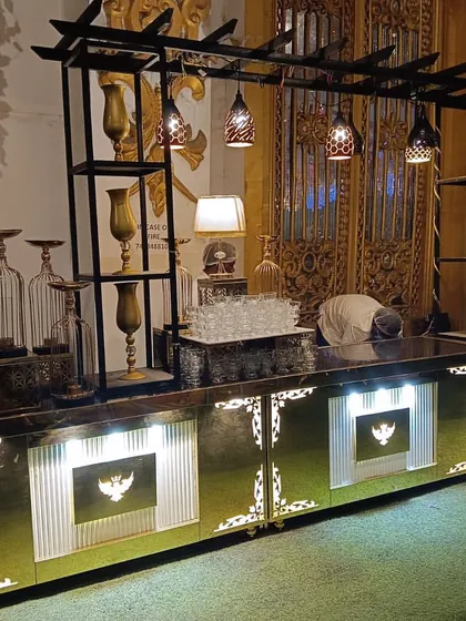 Another angle of our black and gold buffet counter, showing the detailed shelving and decorative framework. This setup is perfect for creating a distinct bar or food station within a larger event space.