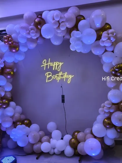 The same elegant white and gold balloon circle under cool purple lighting, showing how lighting can change the mood.