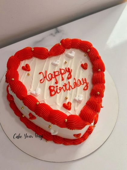 Sweet love, sweeter cake. A classic red and white heart-shaped birthday cake.