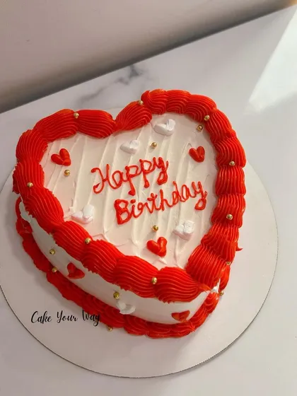 Sweet love, sweeter cake. A classic red and white heart-shaped birthday cake.