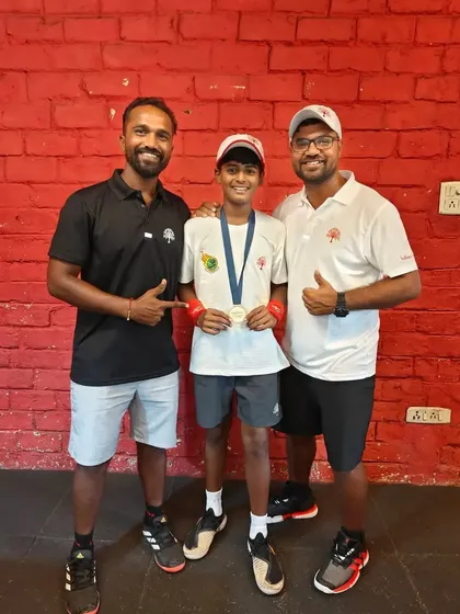 The coaching team celebrating with Rishikesh Mane after his silver medal performance for Team India. Our collaborative coaching approach ensures every player gets the support they need to reach their peak potential.