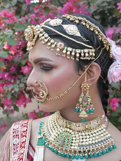 A detailed close-up of the eye makeup, jewelry, and 'matha patti' on our transformed bride.