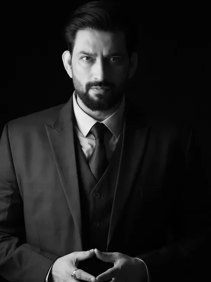 A powerful, low-key portrait of Aadesh Chaudhary. The dramatic shadows create a sense of intensity and focus.