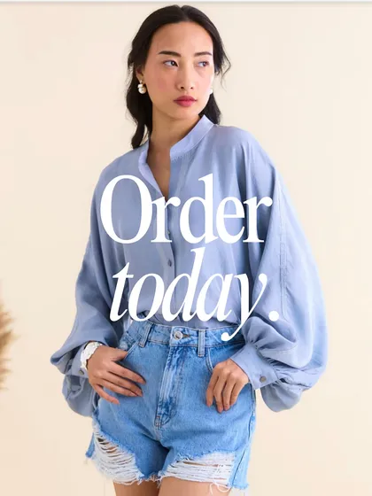 A front view of the "Let Me Be Free" shirt, styled with denim shorts. It’s a testament to my philosophy of creating versatile pieces that you can style your way and feel freedom in.