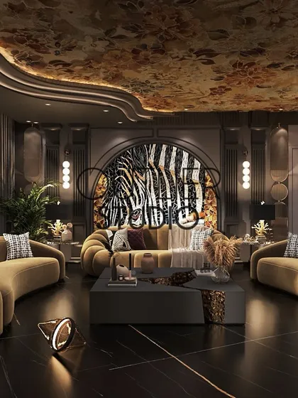 A luxurious lounge area designed for connection. Curved mustard sofas are arranged for conversation, set against a backdrop of a dramatic zebra-print feature wall and a beautifully painted ceiling.