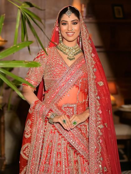A smiling model in a red lehenga, showing how my rental outfits can make anyone feel like a star.