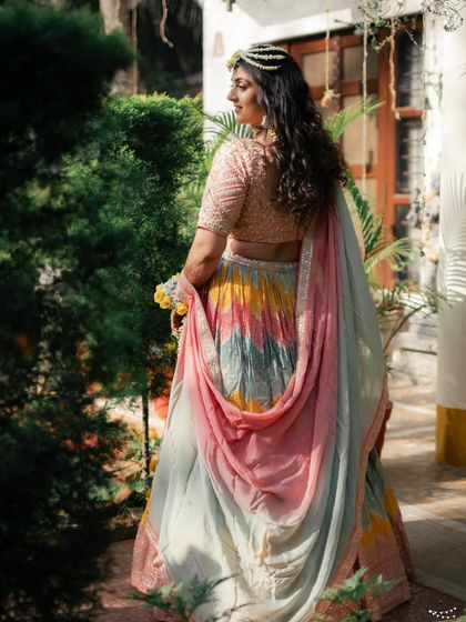 A back view showing the beautiful drape of the dupatta and the soft waves in her hair, completing the perfect Haldi look.