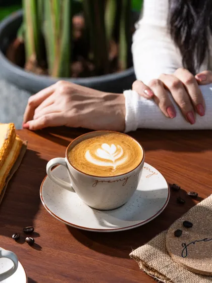 A lifestyle shot at Gremy, showing a customer enjoying a coffee. This helps to create a relatable brand image.