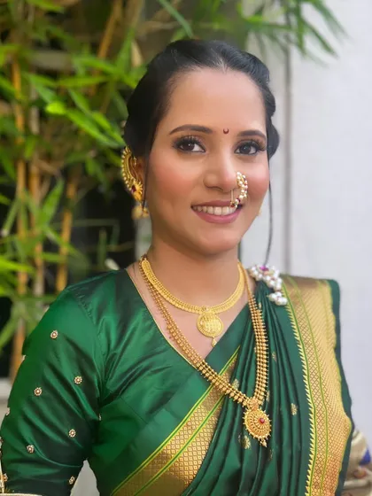 Subtle elegance for a bride in a green saree. The makeup is soft and natural, with a focus on enhancing her features.