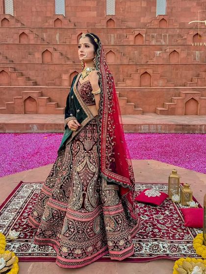 Feel like royalty in this magnificent bridal lehenga. The deep velvet, combined with intricate zardozi and paisley motifs, is designed for a bride who wants to make a grand entrance.