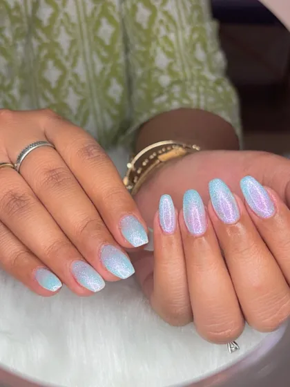 Ombré pearl glitter nails that fade from a soft blue to a shimmery white.