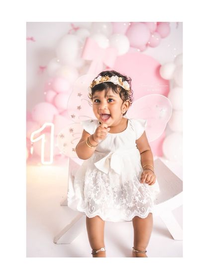 A cheeky tongue-out smile from this one-year-old birthday girl. Her personality shines in this pink bow-themed setup.