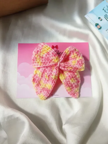 A beautiful multi-color Sailor Bow in shades of pink and yellow. The variegated yarn makes each bow slightly unique.