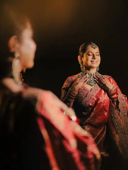 A creative reflection shot. We captured the bride's joyful expression in a mirror, adding depth and an artistic perspective to this bridal portrait.