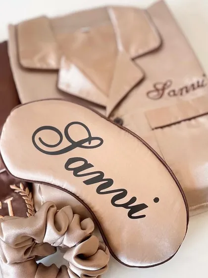 The perfect accessories for your bride tribe. This shot shows a personalised satin sleep mask and a matching scrunchie, part of our custom bridesmaid nightwear collection.