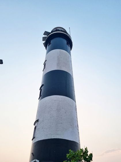 The historic Kapu Lighthouse near Udupi, standing tall against the evening sky. Climbing it offers panoramic views of the coast.