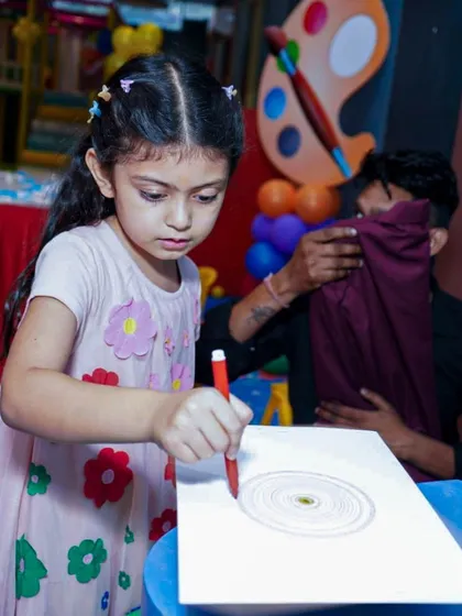 A young guest is completely focused on her spiral art creation, one of the many engaging activities at our art-themed parties.