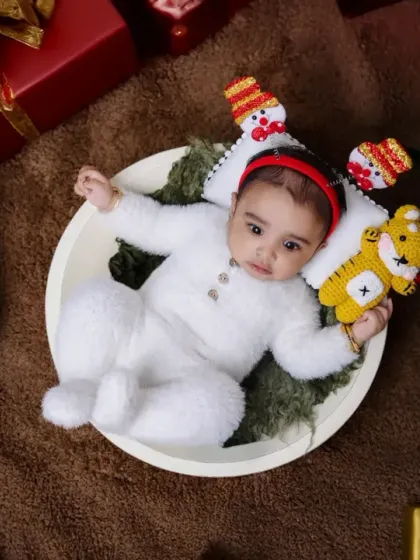 Another angle from our Christmas baby photoshoot. The overhead shot shows the baby nestled among presents, capturing the feeling of him being the greatest gift of all.