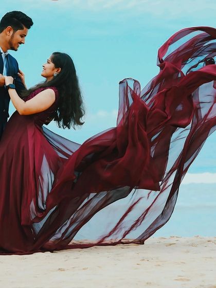 A stunning, color-enhanced photo showing the dramatic trail of this gown against the blue sky. Perfect for couples who want a vibrant and "filmy" pre-wedding shoot.